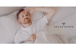 Person experiencing overheating in bed during sleep