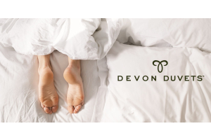 Feet comfortably resting at the bottom of a bed, conveying the calm sleep environment created by using temperature-regulating bedding to ease RLS.
