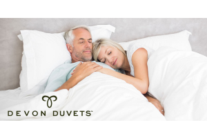 Elderly couple cozy and content under a Devon Duvets wool duvet, enjoying a comfortable and restful sleep.