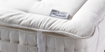 How can a wool mattress topper help keep you cool in the warmer months?