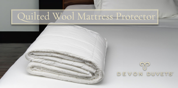 Quilted Wool Mattress Protector elegantly folded on a bed, showcasing its quality and the cosy protection it offers.