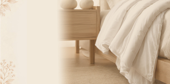 a white wool duvet hanging off the side of the bed in a modern bedroom. 