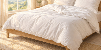 illustration of a very large white duvet on a bed folded.