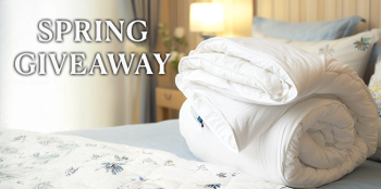 Rolled lightweight wool duvet on a spring-themed bed, promoting Devon Duvets’ seasonal giveaway.