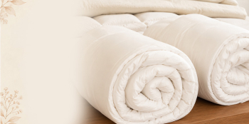 two wool duvets rolled up with a fade to the left.