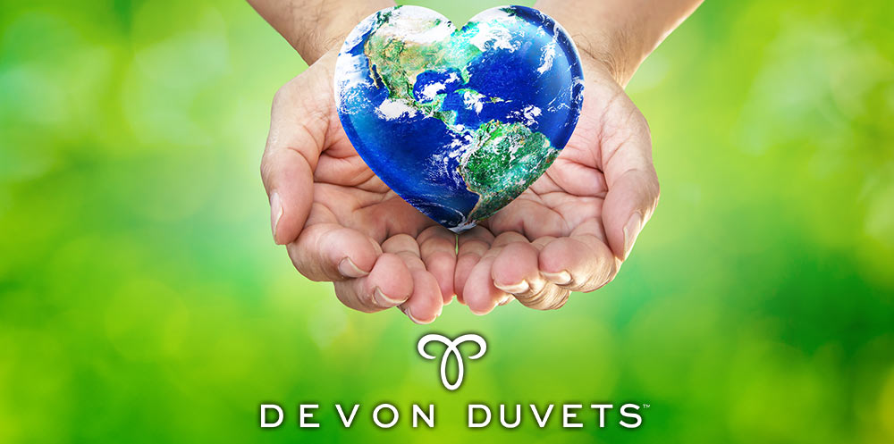 A hand cradling a heart-shaped Earth, symbolizing Devon Duvets' dedication to protecting the planet from plastic pollution.