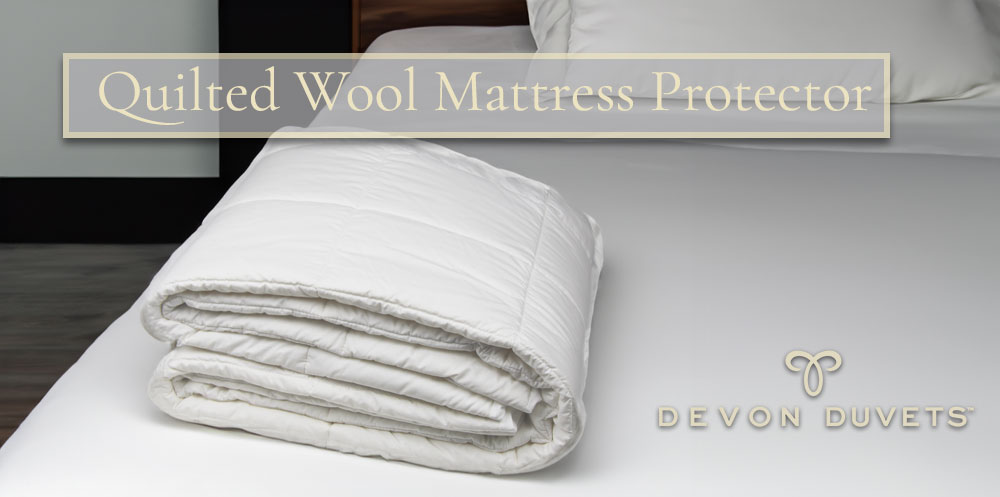 Quilted Wool Mattress Protector elegantly folded on a bed, showcasing its quality and the cosy protection it offers.