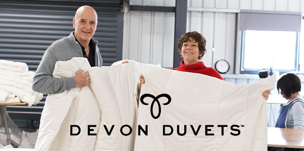 Dick and Pauline, founders of Devon Duvets, proudly presenting their handcrafted British wool duvet.