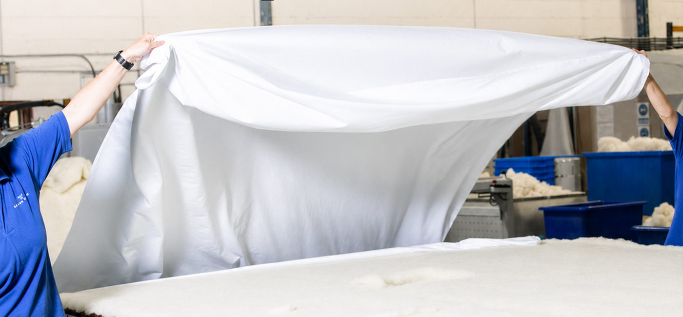 Premium cotton casing visible beneath the bed linen on a natural wool duvet.