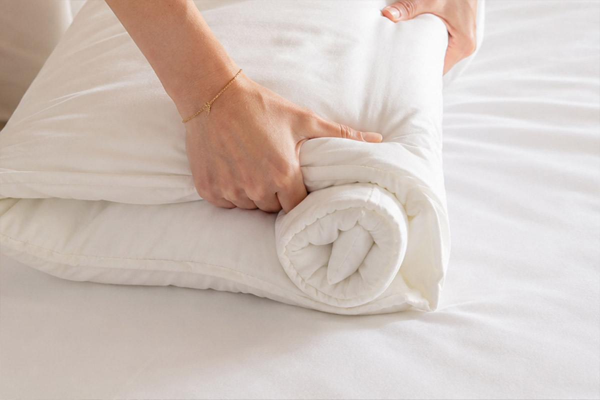 Natural wool, cotton and responsibly made bedding in warm neutral tones