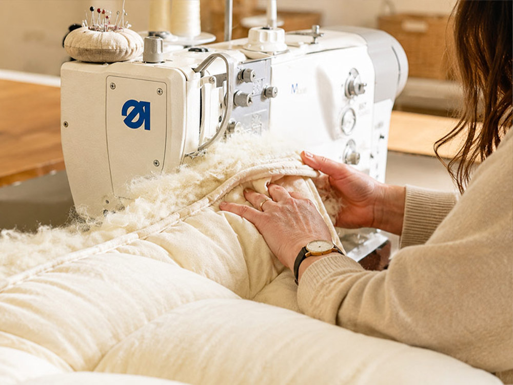 A Devon Duvets maker checking a finished piece of bedding.
