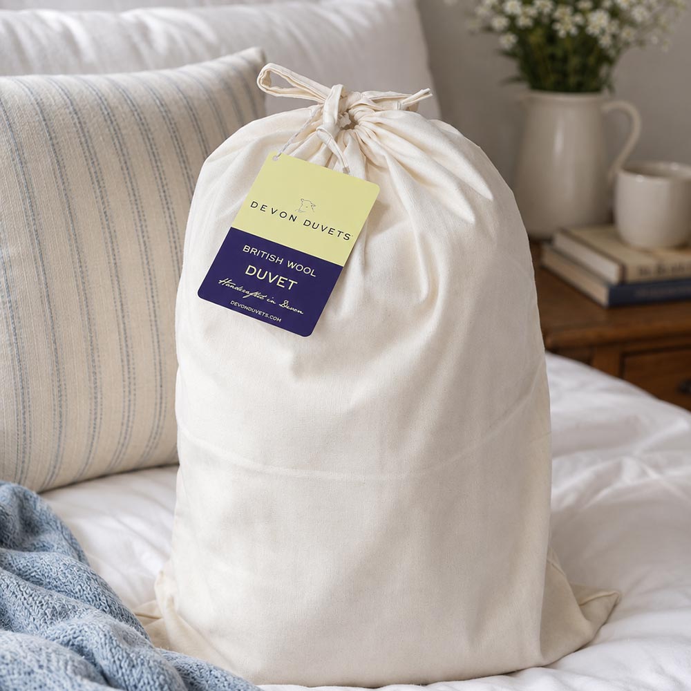 Wool duvet stored inside a breathable cotton storage bag.
