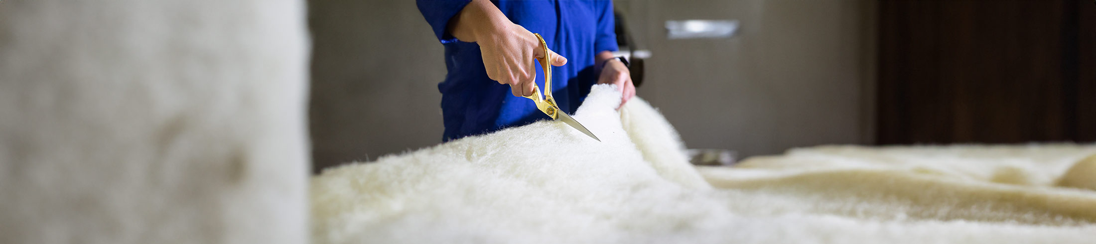 Artisan measuring fabric for bespoke bedding, embodying the precision and care in handmade UK products.