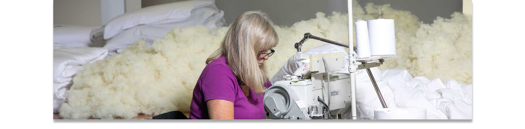 Devon Duvets seamstress expertly crafting bedding, highlighting attention to detail and quality.