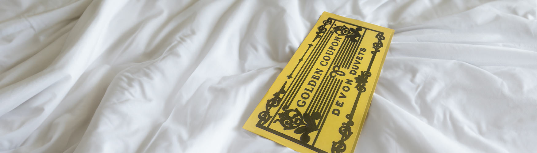 Golden Voucher nestled in a luxurious mattress topper, symbolising surprise and warmth.