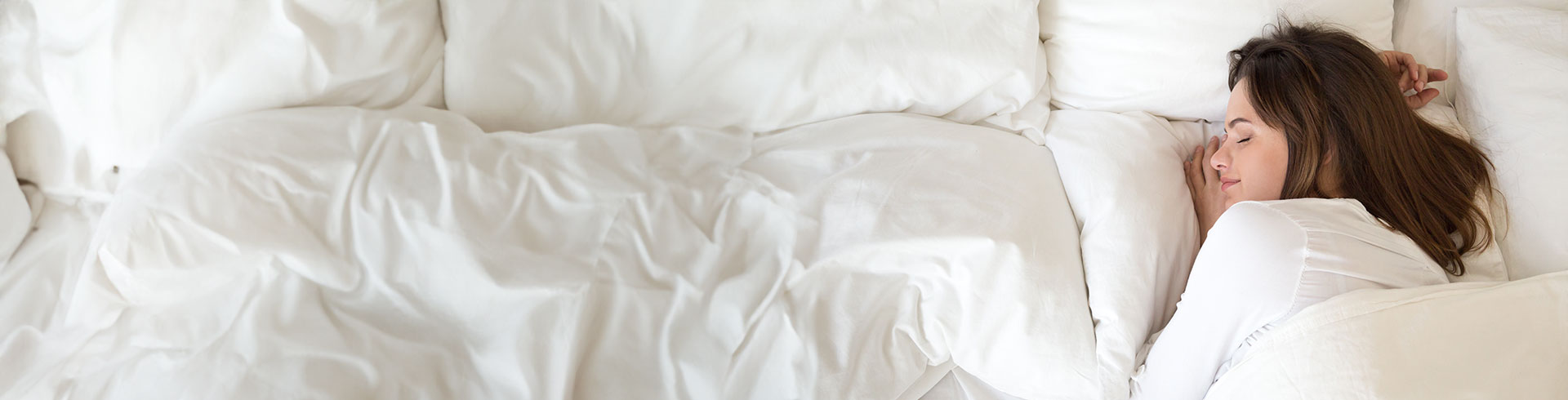 Content woman enjoying restful sleep under a Devon Duvets product.