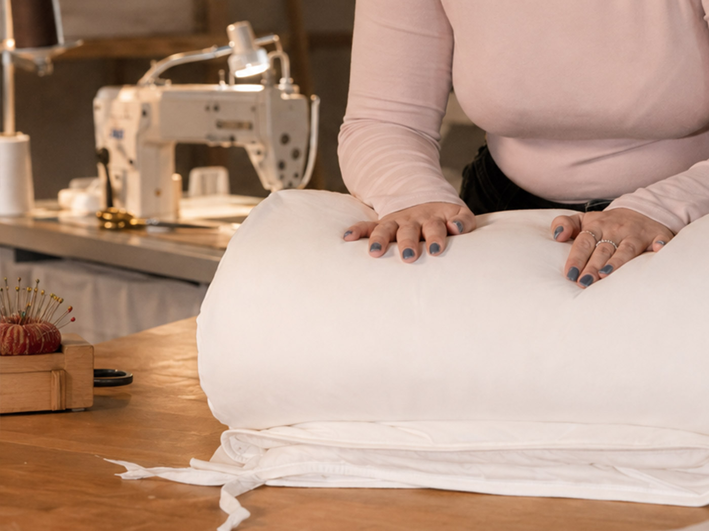 Finished cotton-covered wool bedding being carefully folded and packed by hand