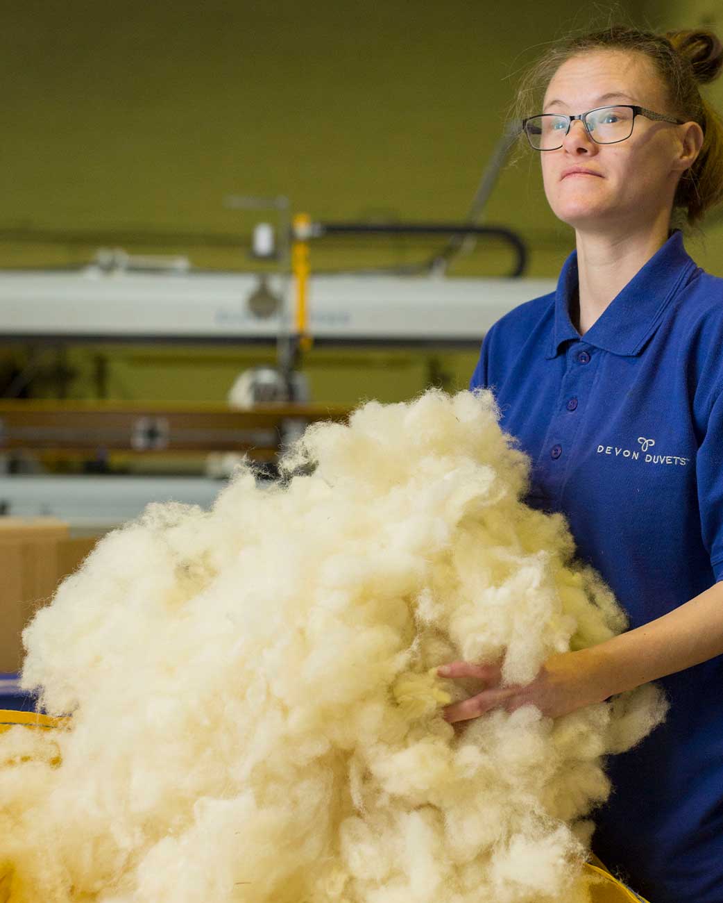 Devon Duvets worker inspecting premium British wool for sustainable bedding products.