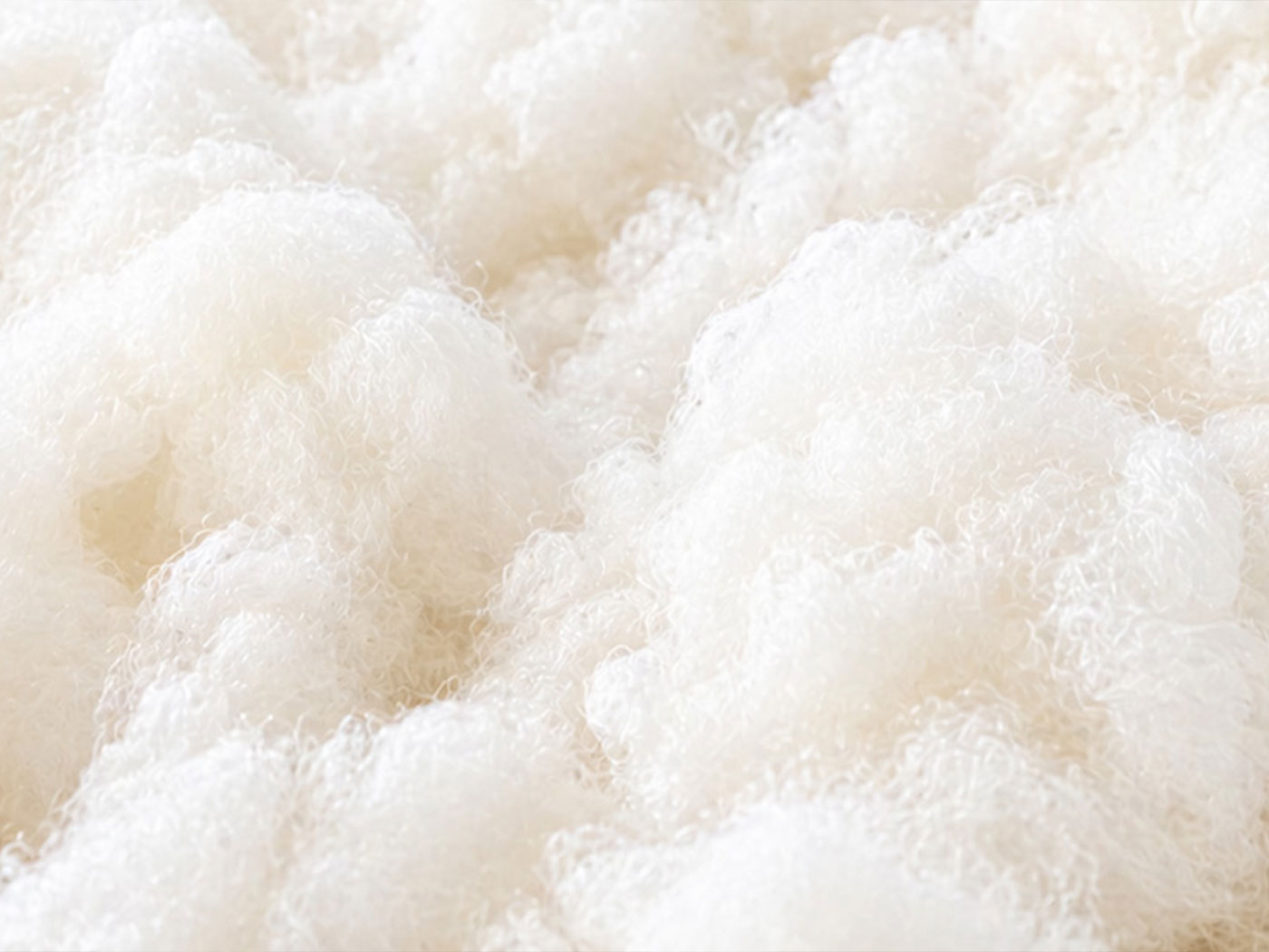 Naturally ivory-white wool fleece spread across a wooden sorting table